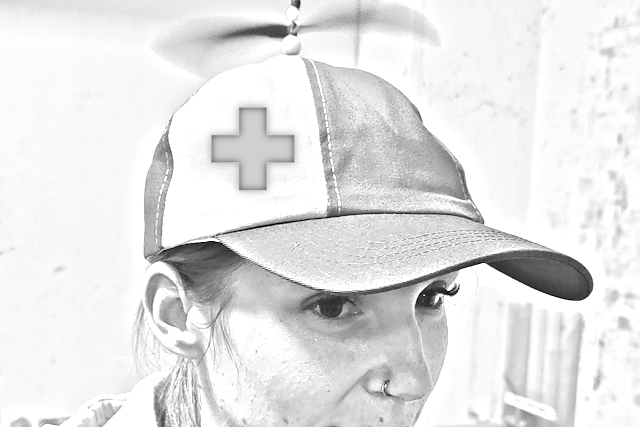 Eine Person, die eine Propellermütze mit einem medizinischen Kreuz trägt.